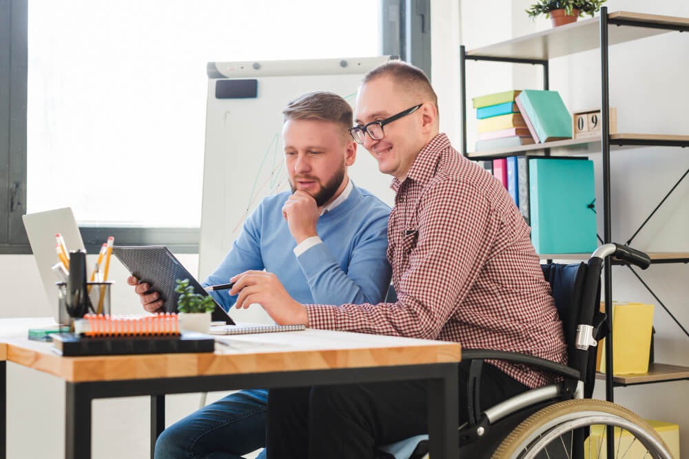 Positive disabled worker together with manager at the office.jpg